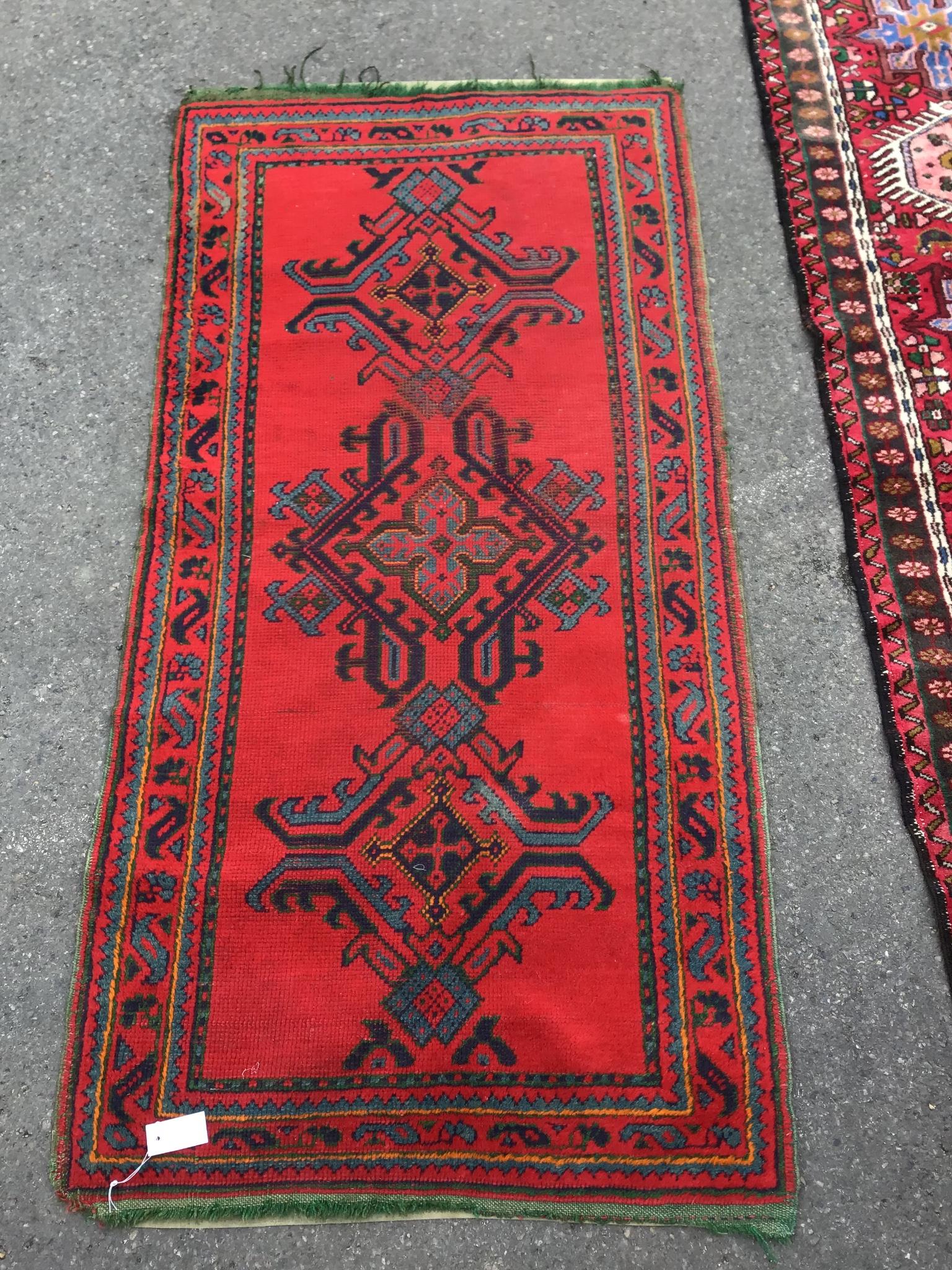 An Afghan red ground rug, 184 x 90cm